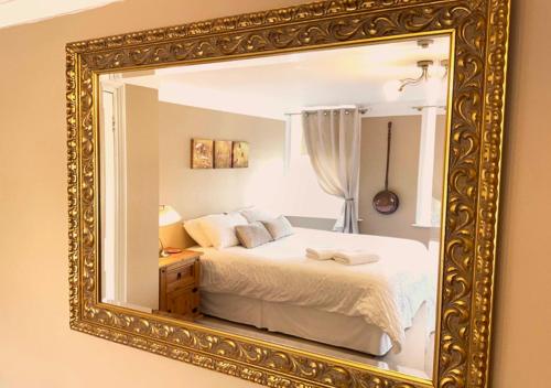 a bedroom with a bed in a gold framed mirror at The Georgian Apartment in Gosport