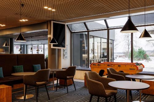 un restaurant avec des tables, des chaises et un billard dans l'établissement Radisson Blu Hotel Espoo, à Espoo