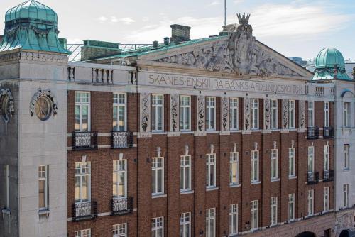 a large brick building with a clock on it at The Vault Hotel, WorldHotels Crafted in Helsingborg