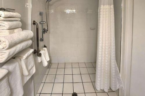 a bathroom with a shower with white towels at Quality Inn & Suites in Clearwater
