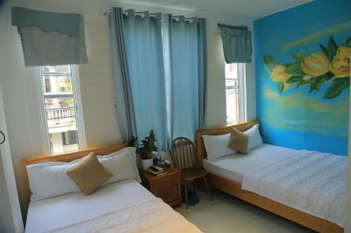 um quarto com duas camas e um quadro na parede em Sông Suối Homestay em Quy Nhon