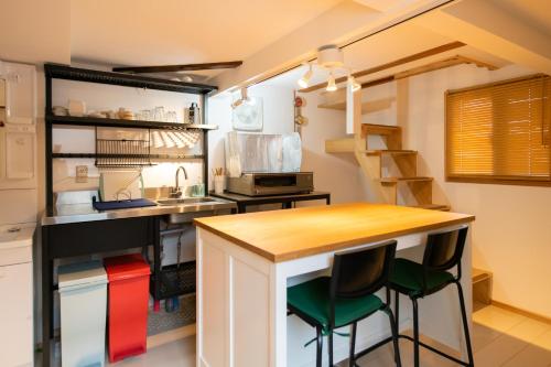 a small kitchen with a counter and stools at Destiny Inn Sakaiminato in Sakaiminato