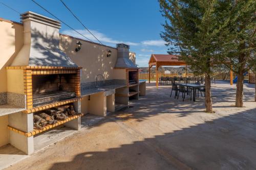 a building with a pizza oven with a picnic table and a table at CASA RURAL VICENTA 1750 in Albentosa