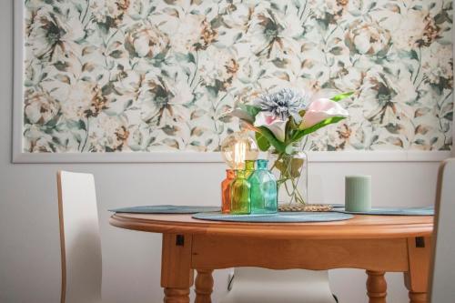 a dining room table with a vase of flowers on it at Luxury Singular Apartments Green in Santiago de Compostela