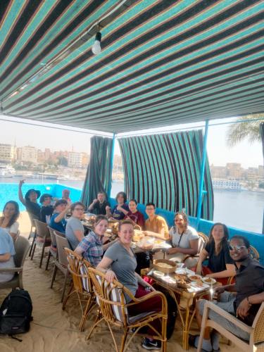 a group of people sitting at tables in a restaurant at Jamaica Guest House in Aswan