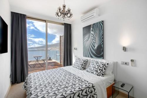 een slaapkamer met een bed en een groot raam bij Mirador Terrazas del Mar in Santa Cruz de Tenerife