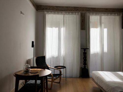 a bedroom with a bed and a table and a chair at Belomonte 20 Apartments Porto World Heritage in Porto