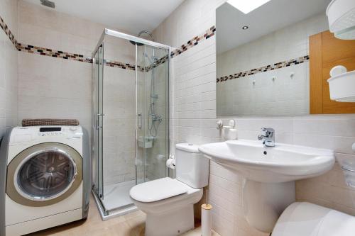 a bathroom with a washing machine and a sink at Casa Mar y Luz in Morro del Jable