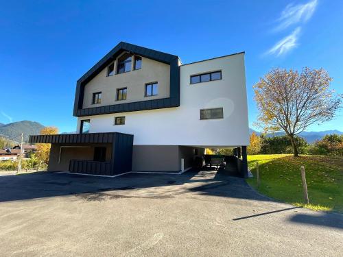 ein großes weißes Haus mit schwarzem Dach in der Unterkunft Lebenskraft-Apartments in Reutte