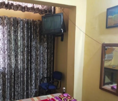 TV en una habitación con ventana y cama en Hotel Darpan By WB Inn en Jammu