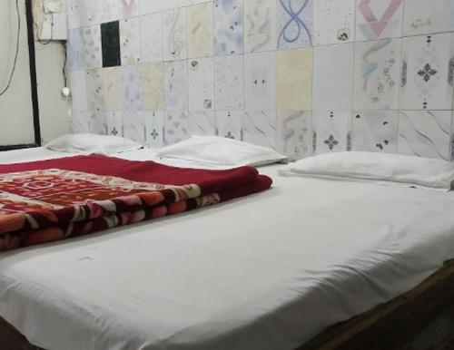 uma grande cama branca com um cobertor vermelho em Hotel Darpan By WB Inn em Jamu