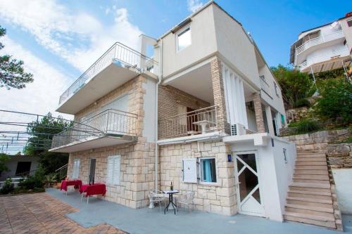 a house with a staircase and red chairs in front of it at Vila Dvorski in Baška Voda