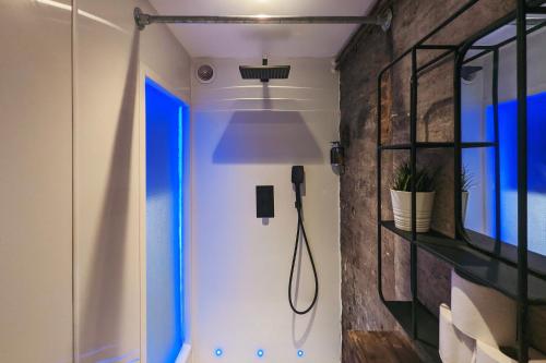 a bathroom with a shower with blue lights on the wall at Blayds Yard in Leeds