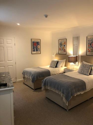 een slaapkamer met 2 bedden en een keuken met 2 lampen bij Websters Bed & Breakfast in Salisbury