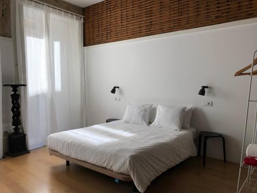 een slaapkamer met een bed met witte lakens en een raam bij Belomonte 20 Apartments Porto World Heritage in Porto
