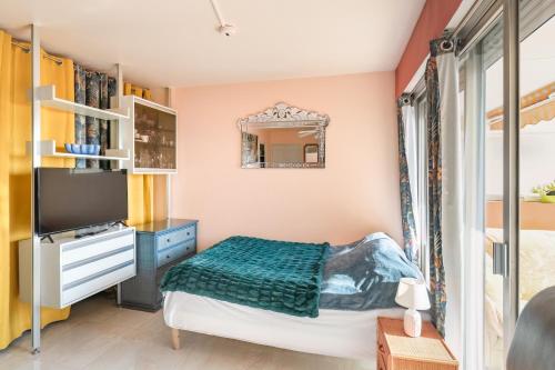 une petite chambre avec un lit et un miroir dans l'établissement Apartment Boulouris, à Saint-Raphaël