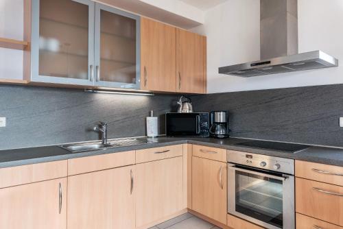 a kitchen with wooden cabinets and a sink at Alpin Farm Birke - Oberweidacherhof in Collalbo