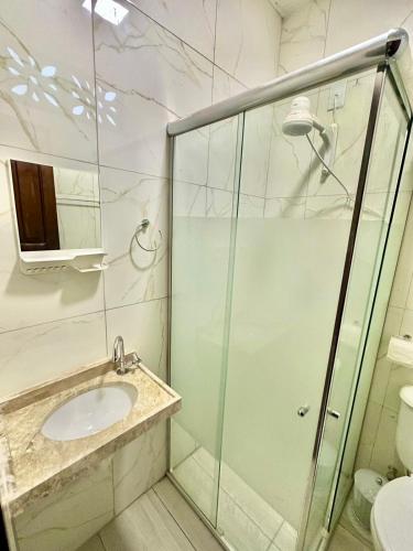 a bathroom with a sink and a glass shower at Home Beach Mar Conforto Self-Hosted in Aquiraz