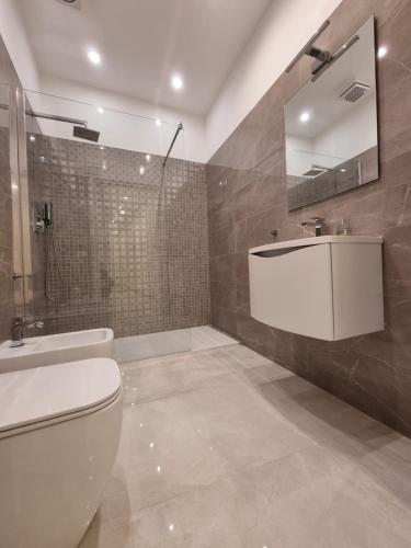 uma casa de banho com um WC, um lavatório e um espelho. em Genoa Lux Apartments with parking em Gênova