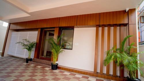 a building with palm trees in front of it at Revostay Royel by Crossway in Chennai