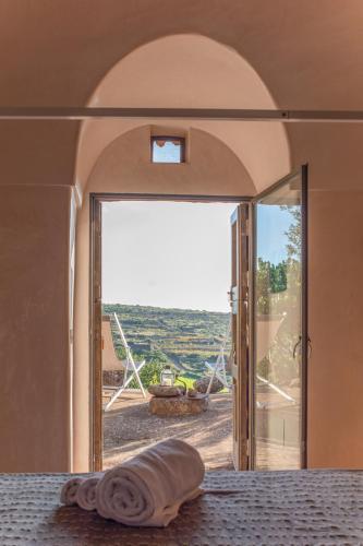 a room with a bed with a view of the ocean at Dammusi IL SERRALH -Pantelleria- in Pantelleria
