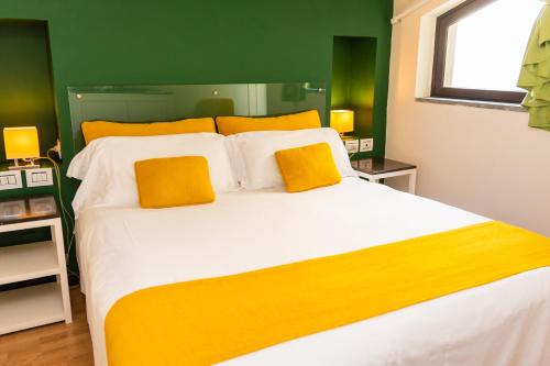 a bedroom with a large bed with yellow and green walls at Grand Hotel Villa Itria Congress & Spa in Viagrande