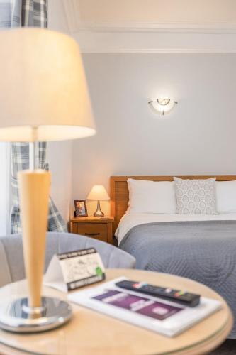 a bedroom with a bed and a table with a lamp at The Black Swan Inn in Pickering