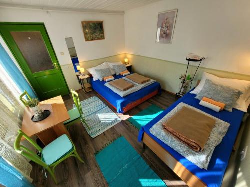 セゲドにあるBrindza Vendégházのベッド2台とテーブルが備わる小さな客室です。