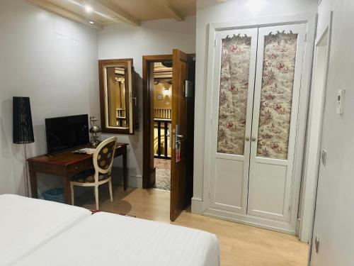 een slaapkamer met een bed, een bureau en een deur bij Sacristia de Santa Ana in Sevilla