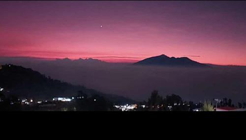 Blick auf den Sonnenuntergang mit einem Berg im Hintergrund in der Unterkunft pandya Bromo in Pasuruan