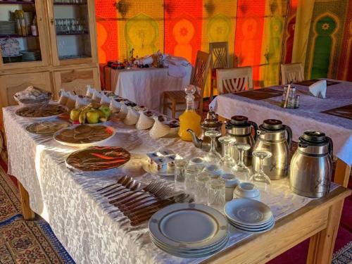 a table with plates of food on top at Erg chebbi Dunes Desert Camp in Merzouga