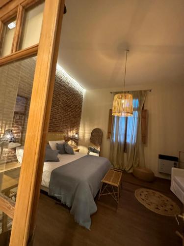 una camera con letto e lampadario a braccio di Tanah Host - Casa de Huespedes a Villa Mercedes