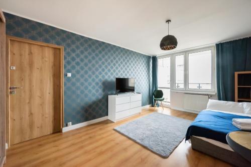 ein Schlafzimmer mit einem Bett und einem TV in der Unterkunft Praga-Południe Blue Studio in Warschau