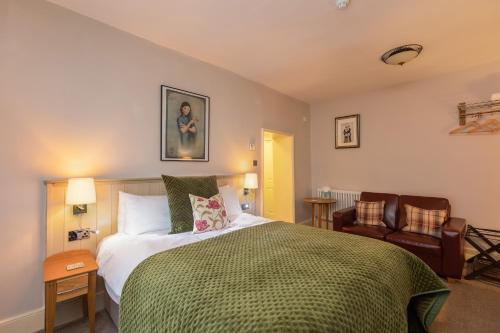 a bedroom with a bed and two chairs in it at The Black Swan Inn in Pickering