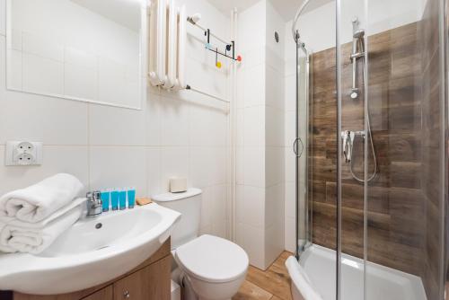 ein Bad mit einem WC, einem Waschbecken und einer Dusche in der Unterkunft Praga-Południe Blue Studio in Warschau