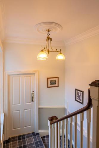 a hallway with a white door and a chandelier at The Black Swan Inn in Pickering