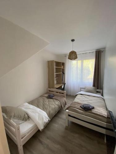 une chambre avec deux lits dans une pièce dans l'établissement Gite de Tréguilly, à Pontchâteau