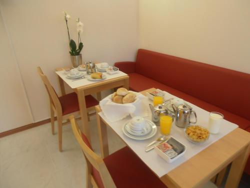 波多的住宿－聖馬利諾酒店，一张桌子,上面有食物和饮料,一张桌子和椅子,上面有桌子