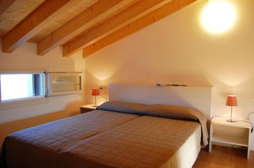 ein Schlafzimmer mit einem Bett und zwei Lampen an zwei Tischen in der Unterkunft Lovely flat with swimming pool in Bibione in Bibione