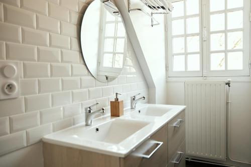 a bathroom with a sink and a mirror at La Maison du Gasseau in Saint-Léonard-des-Bois