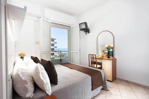 a bedroom with a bed with a view of the ocean at Hotel Croce del Sud in Cesenatico