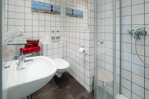 y baño con lavabo, aseo y ducha. en Villa Marie Wohnung 1, Norderney en Norderney