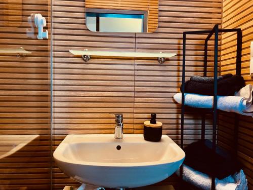 ein Badezimmer mit einem weißen Waschbecken und einem Spiegel in der Unterkunft Haus am See mit Steg, Boot, Kamin und Sauna - Mecklenburgische Seenplatte in Blankensee