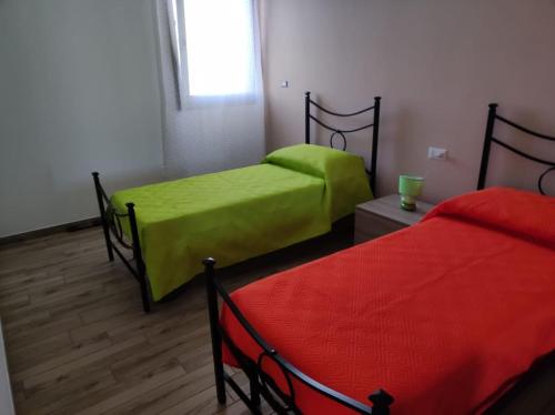 two beds with green sheets in a room at Holiday Home La Perla in Presicce