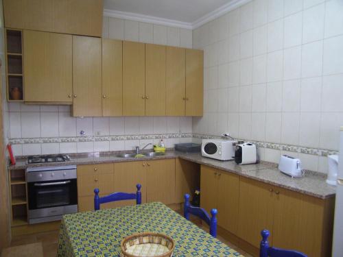 a kitchen with wooden cabinets and a table in it at Quinta De Azemeis in Vimieiro