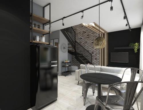 Il comprend une cuisine et une salle à manger avec un réfrigérateur noir et une table. dans l'établissement N23 Dwupoziomowy Apartament Łódź Centrum Wi-Fi Klimatyzacja, à Łódź