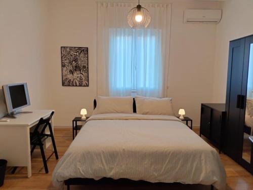 1 dormitorio con 1 cama y escritorio con ordenador en B&B Tanto Piacere Taranto, en Taranto