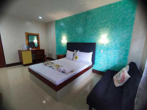 a bedroom with a bed and a blue wall at Calicoan Villa in Sarog