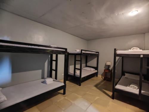 a room with three bunk beds in it at Calicoan Villa in Sarog