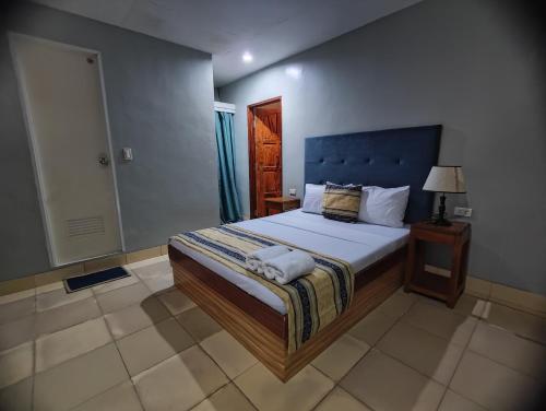 a bedroom with a large bed with a blue headboard at Calicoan Villa in Sarog